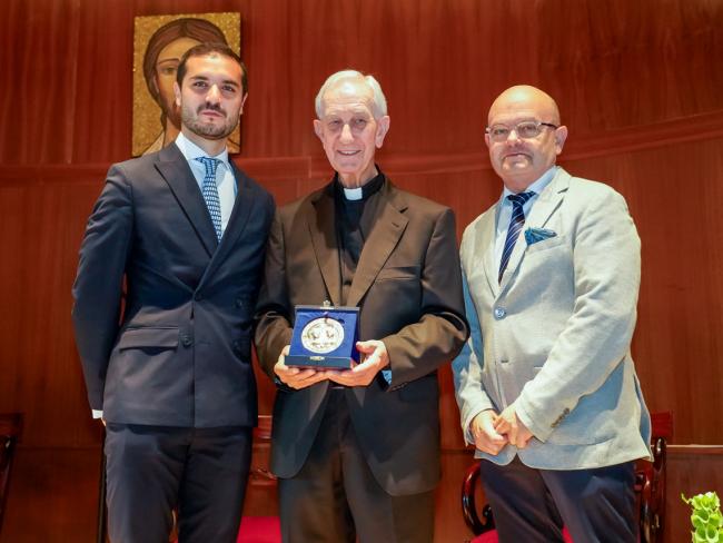 El alcalde, Alejandro Navarro Prieto, y el primer teniente alcalde, Valeriano Díaz, con el sacerdote D. Florentino Rueda, que enseña la Medalla “Pro Ecclesia Complutensi” recibida  