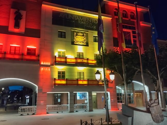 La fachada del Ayuntamiento engalanada con las banderas de España e iluminada con los colores de la enseña nacional