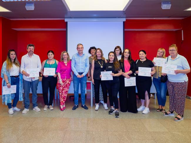El concejal de Bienestar, Educación e Inmigración, Rubén Martínez, y los padres y madres participantes en el programa, quienes recibieron un diploma que acredita la formación recibida